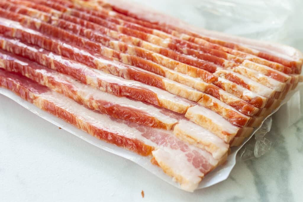 Raw bacon in package on counter.
