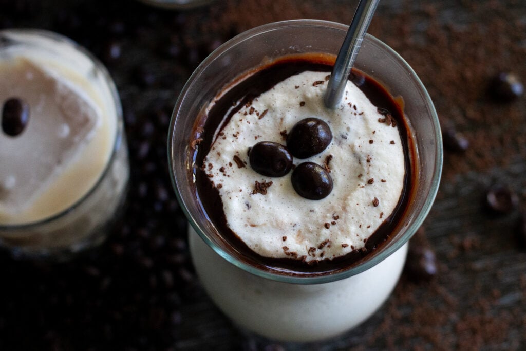 Looking down at a frozen mudslide drink, garnished with chocolate sauce, chocolate shavings and chocolate-covered espresso beans.