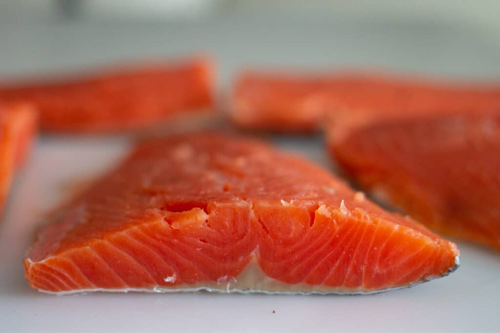 Close up of sockeye salmon fillet on cutting board.