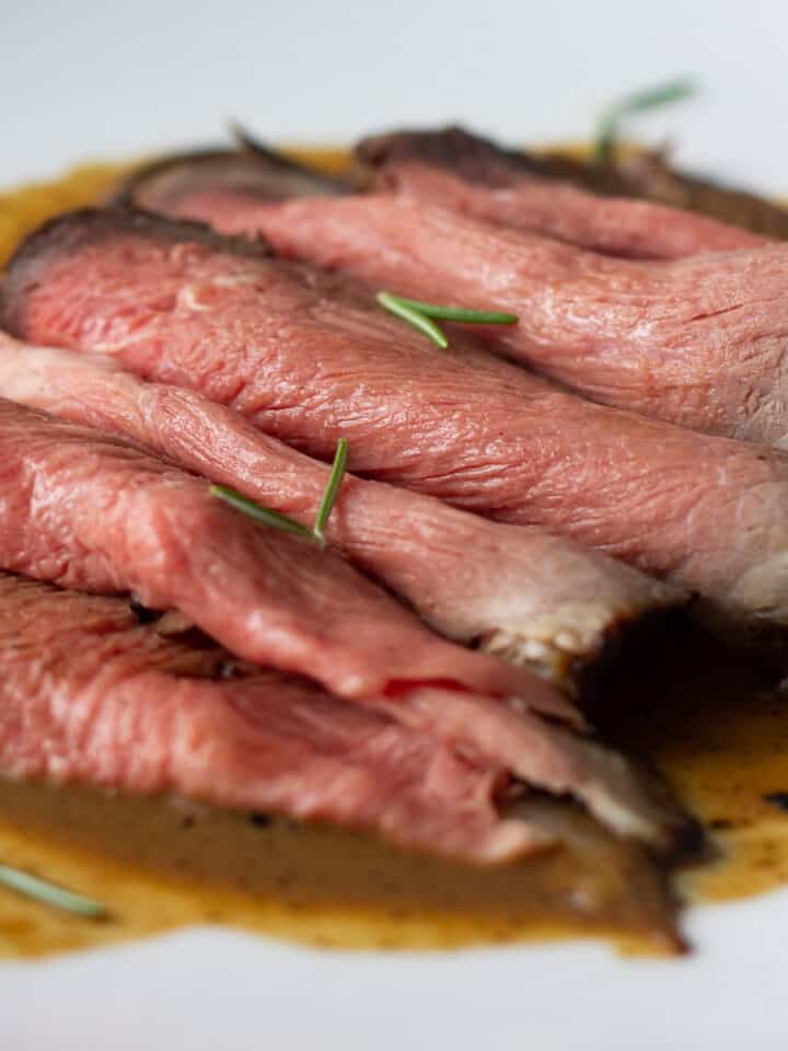 Simple beef jus poured over sliced roast beef bottom round.