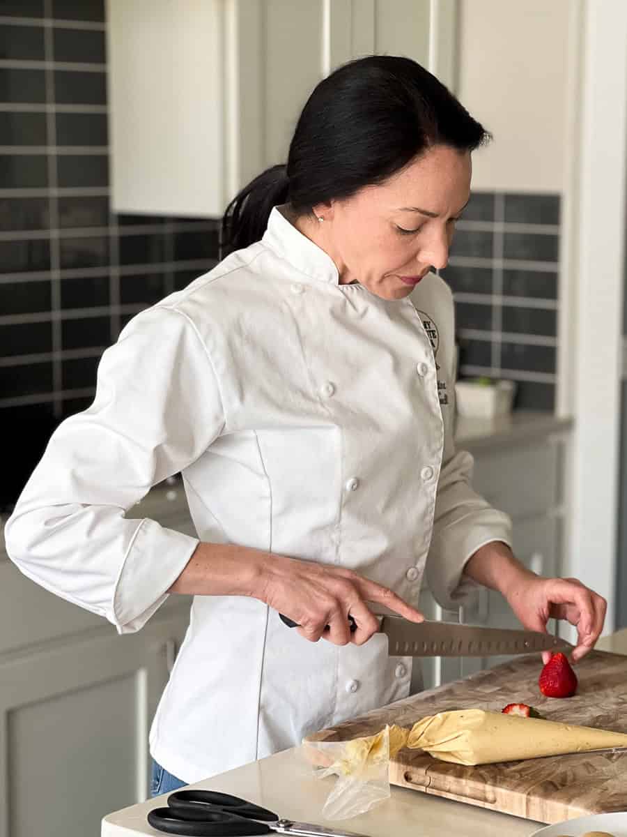 Chef Christina Bailey slicing food for cooking class.